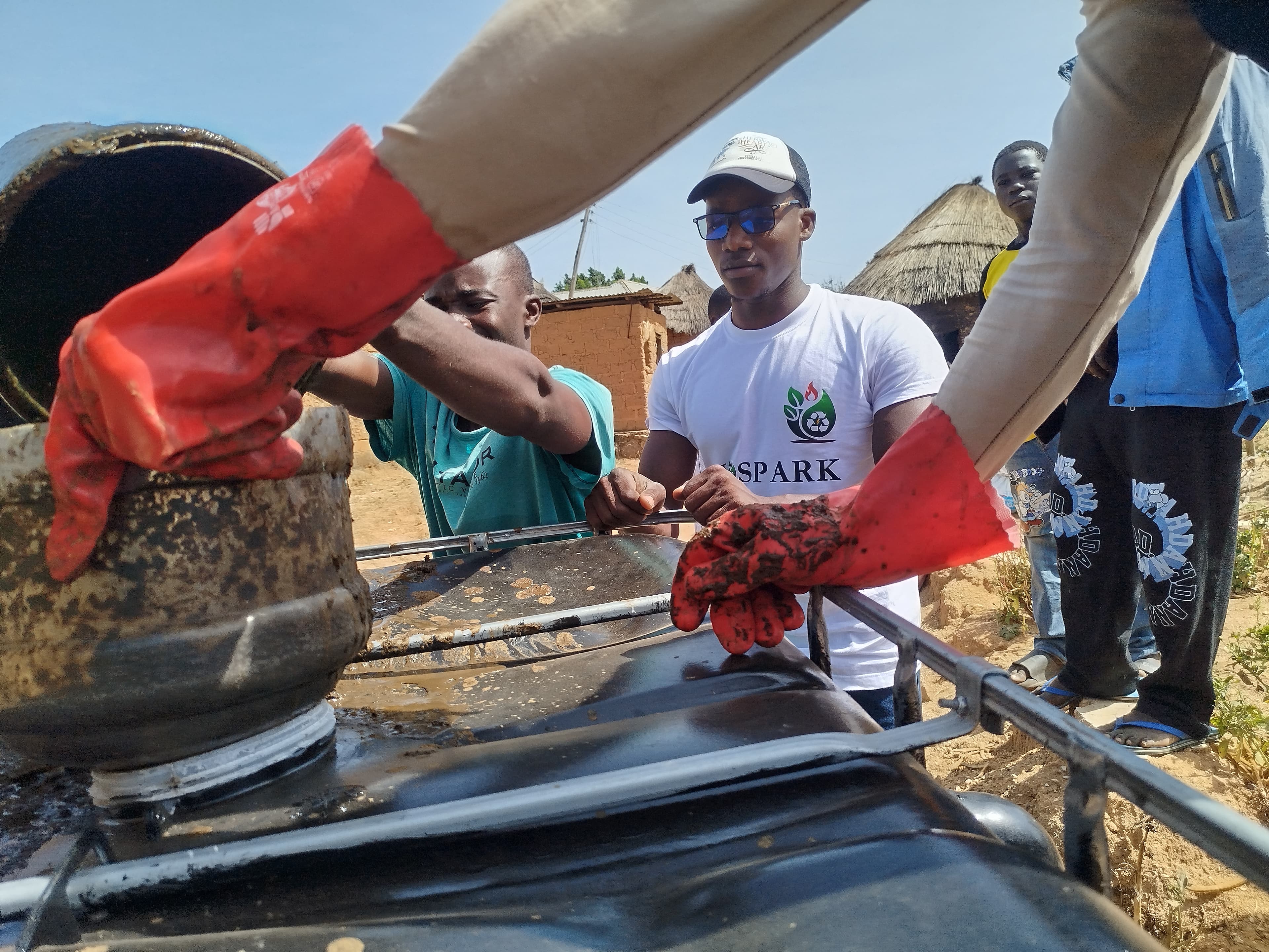 Biospark team maintaining a community biodigester system